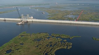 PVED01_076 - 4K aerial stock footage pan across surge barrier and orbit a gate at sunrise in St. Bernard Parish bayou, Louisiana
