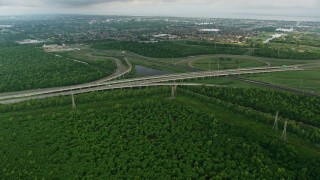 PVED01_084E - 4K aerial stock footage fly over freeway interchange to approach a New Orleans East suburb at sunrise, Louisiana