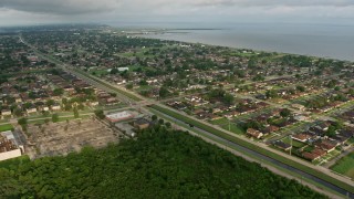 PVED01_088 - 4K aerial stock footage approach suburban neighborhoods by the lake at sunrise in New Orleans East, Louisiana