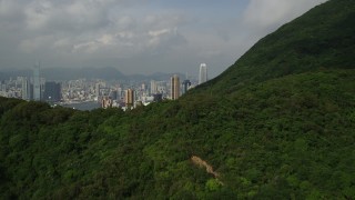 SS01_0038 - 5K stock footage aerial video fly over forest and mountain to reveal skyscrapers on Hong Kong Island, China