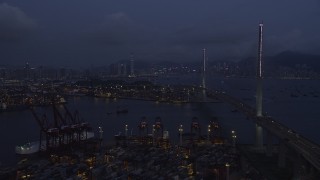 SS01_0115 - 5K stock footage aerial video fly over containers at the Port of Hong Kong toward center of Stonecutters Bridge at night in China