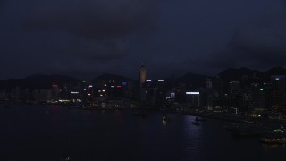 SS01_0131 - 5K stock footage aerial video approach Hong Kong Island high-rises on the shore of the harbor at night, China