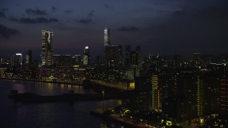SS01_0161 - 5K stock footage aerial video of waterfront hotels near The Masterpiece skyscrapers at night in Kowloon, Hong Kong, China