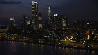 SS01_0163 - 5K stock footage aerial video of hotel overlooking the harbor near The Masterpiece at night in Kowloon, Hong Kong, China