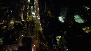 SS01_0196 - 5K stock footage aerial video of following Nathan Road between office and apartment buildings at night in Kowloon, Hong Kong, China