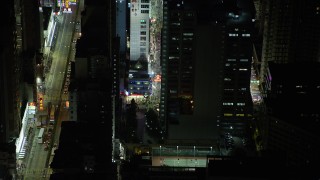 SS01_0206 - 5K stock footage aerial video approach and tilt to a corner shop at night in Kowloon, Hong Kong, China