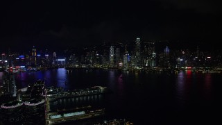 SS01_0215 - 5K stock footage aerial video approach Hong Kong Island skyline from Kowloon piers at night, China