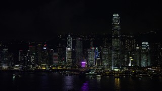 SS01_0217 - 5K stock footage aerial video approach Hong Kong Island skyscrapers across Victoria Harbor at night, China