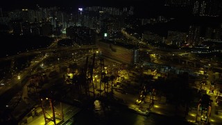 SS01_0240 - 5K stock footage aerial video flyby cargo cranes and wide streets at the Port of Hong Kong at night, China
