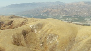 TS01_013 - 1080 stock footage aerial video of fly over hills to reveal farmland in Piru, California