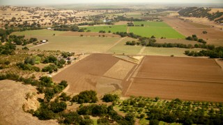 TS01_265 - 1080 stock footage aerial video of flying over farm fields and barns in Capay, California
