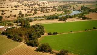 TS01_266 - 1080 stock footage aerial video of flying over farmland and house toward the river in Capay, California