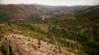 TS01_293 - 1080 stock footage aerial video of mountain highway seen while flying over trees in Sierra Nevada Mountains, California