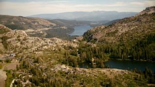 TS01_301 - 1080 stock footage aerial video fly over smaller lake and lodge toward Donner Lake, California
