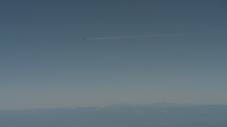 WA001_029 - 4K stock footage aerial video air-to-air view of a jet airplane contrail flying over mountains in Solano County, California