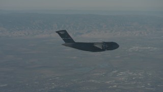 WA001_043 - 4K stock footage aerial video zoom in on a Boeing C-17 flying over Solano County, California