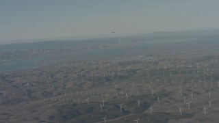 WA001_050 - 4K stock footage aerial video air-to-air view of a jet flying near Suisun Bay and windmills in Solano County, California