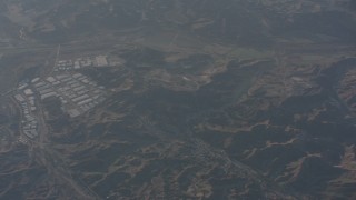 WA002_010 - 4K stock footage aerial video reverse view of hillside homes and warehouse buildings in Castaic, California