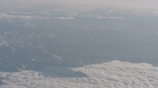 WA002_034 - 4K stock footage aerial video pan across snowy mountains and clouds in the Sierra Nevada Mountains, California