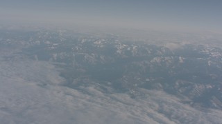 WA002_036 - 4K stock footage aerial video tilt from a bird's eye of clouds to reveal snowy Sierra Nevada Mountains, California