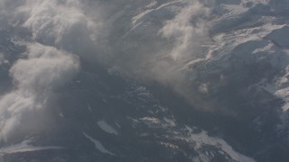 WA002_058 - 4K stock footage aerial video of reverse view of misty clouds rolling over the snowy Sierra Nevada Mountains, California