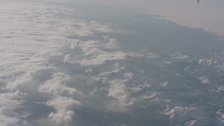 WA002_059 - 4K stock footage aerial video tilt and fly away from clouds over snowy Sierra Nevada Mountains, California