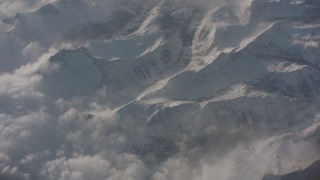 WA002_060 - 4K stock footage aerial video tilt and fly away from misty clouds over snowy Sierra Nevada Mountains, California