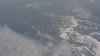 WA002_072 - 4K stock footage aerial video pan across clouds and Lake Tahoe to reveal snowy mountains, California