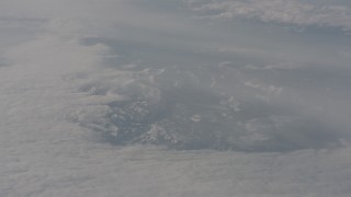 WA002_079 - 4K stock footage aerial video of reverse view of the Sierra Nevada Mountains surrounded by a layer of clouds, California