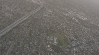 WA003_024 - 4K stock footage aerial video pan across neighborhoods to reveal I-105 with heavy traffic in Lynwood, California