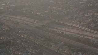 WA003_026 - 4K stock footage aerial video pan across I-105 to reveal the Lear jet landing gear as the plane approaches Hawthorne Airport, California