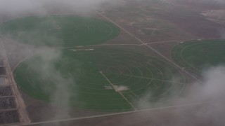 WA005_028 - 4K stock footage aerial video flyby clouds to reveal circular crop fields in Kansas