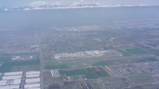WA007_044 - 4K stock footage aerial video tilt from construction areas to reveal Chino Airport and snowy mountains, Chino, California