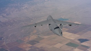 WAAF01_C019_0117VJ - 4K stock footage aerial video of passing behind a Lockheed C-5 flying over farmland in Northern California