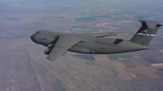 WAAF01_C021_0117TP - 4K stock footage aerial video of flying beside a Lockheed C-5, pull back for wider view over Northern California
