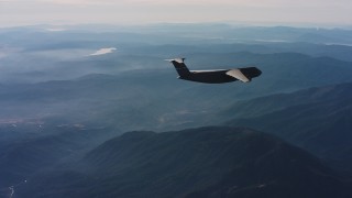WAAF01_C027_0117SH - 4K stock footage aerial video of a Lockheed C-5 flying over mountains in Northern California