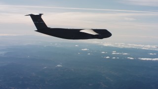 WAAF01_C037_0117CB - 4K stock footage aerial video fly beside a Lockheed C-5 flying over mountains in Northern California