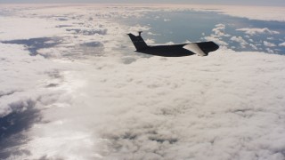 WAAF01_C046_011778 - 4K stock footage aerial video of a Lockheed C-5 firing flares over cloud cover in Northern California