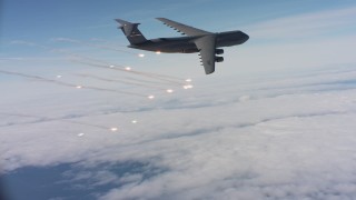 WAAF01_C048_0117DF - 4K stock footage aerial video of a Lockheed C-5 firing flares over clouds in Northern California