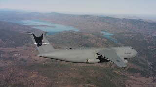 WAAF01_C074_0117TM - 4K stock footage aerial video of a Lockheed C-5 flying over mountains near a lake, Northern California