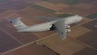 WAAF01_C079_0117FV - 4K stock footage aerial video of a Lockheed C-5 in flight over farm fields in Northern California
