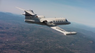WAAF02_C004_0117QQ - 4K stock footage aerial video of a Learjet C-21 in flight over hills of Northern California