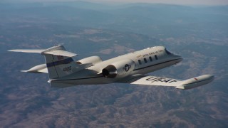 WAAF02_C009_01170N - 4K stock footage aerial video of flying around the tail of a Learjet C-21 over Northern California