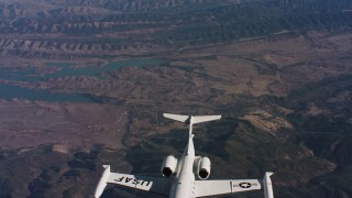 WAAF02_C018_0117VQ - 4K stock footage aerial video revealing a Learjet C-21 rising into frame over hills and a lake in Northern California