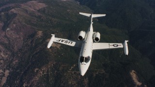 WAAF02_C019_0117JN_S000 - 4K stock footage aerial video of a reverse view of a Learjet C-21 flying over mountains in Northern California