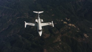 WAAF02_C019_0117JN_S003 - 4K stock footage aerial video of panning across mountains to reveal a Learjet C-21 in Northern California