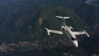 WAAF02_C020_0117TR - 4K aerial stock footage video of tracking a Learjet C-21 in flight over mountains in Northern California