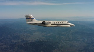 WAAF02_C028_0117BJ - 4K stock footage aerial video of a Learjet C-21 plane flying over mountains in Northern California