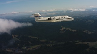 WAAF02_C031_01177D - 4K stock footage aerial video of a Learjet C-21 in the air over mountains in Northern California