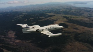 WAAF02_C032_0117R3 - 4K stock footage aerial video of a Learjet C-21 flying above mountains in Northern California